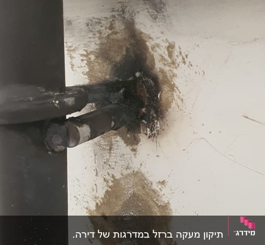 מסגרת מתכת מחוברת לקיר עם כתמי חלודה